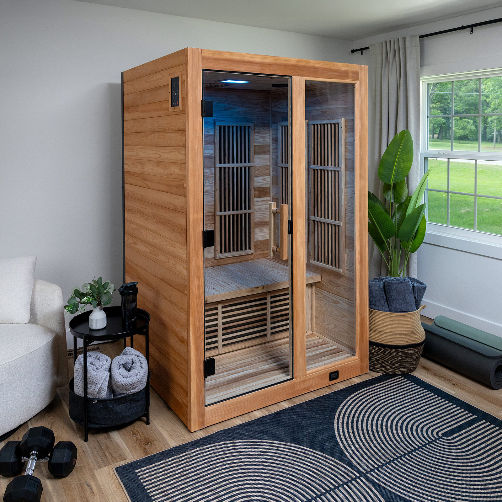 Modern two-person infrared sauna with glass door installed in home wellness room