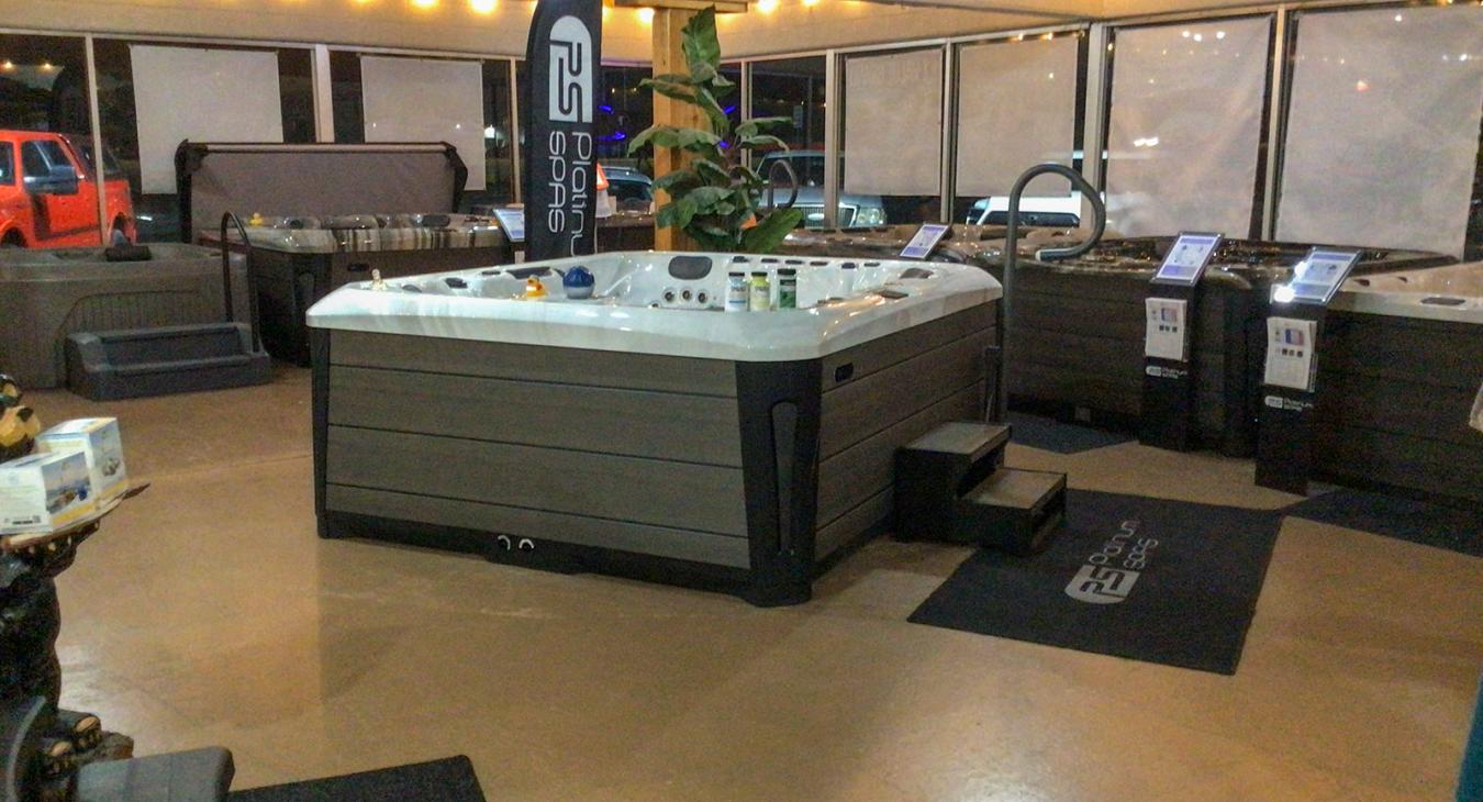Family Time Spas showroom in the evening with multiple hot tubs on display and warm interior lighting.
